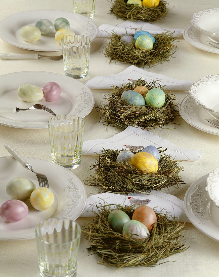 Gedeckter Tisch mit Osternest und marmorierten Eiern