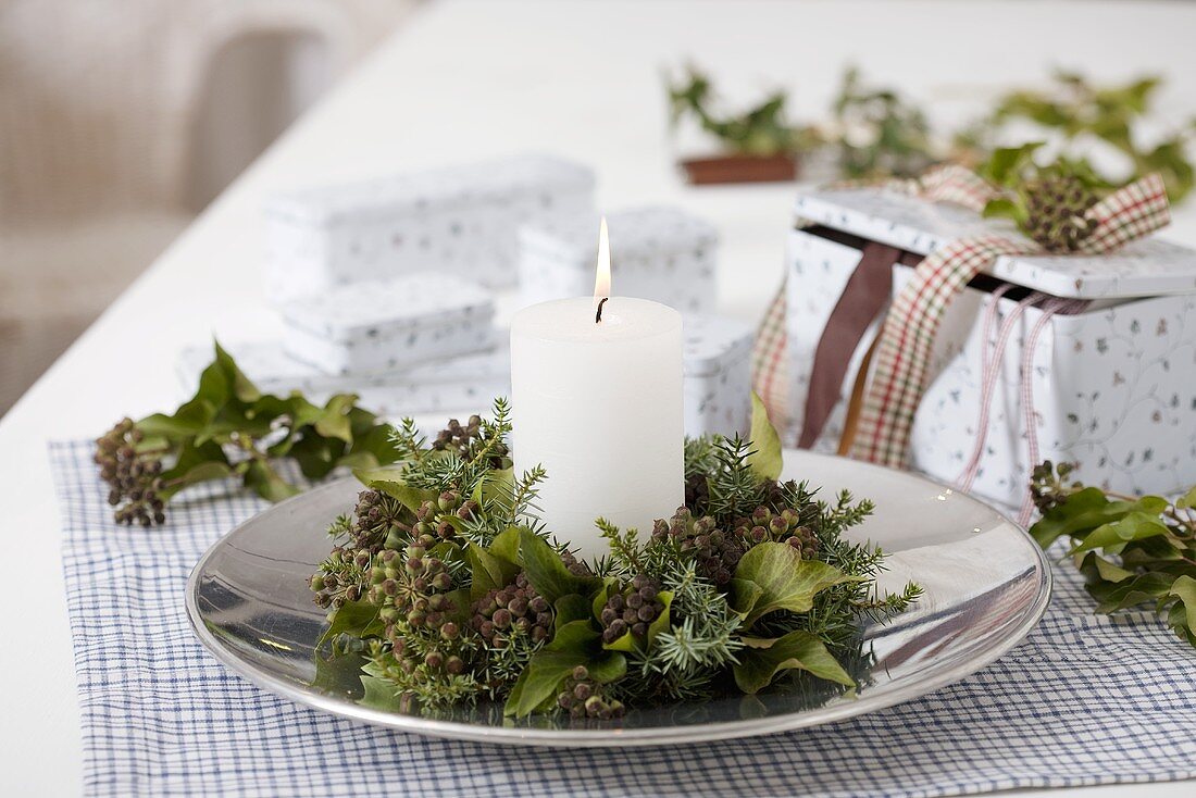 A candle with wreath of ivy and juniper