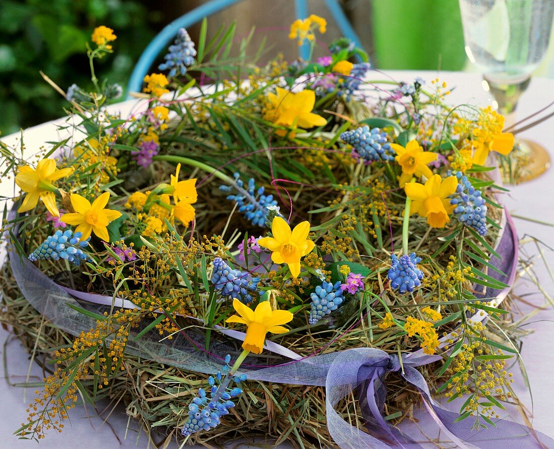 Wreath of hay, narcissi, grape hyacinths and mimosa