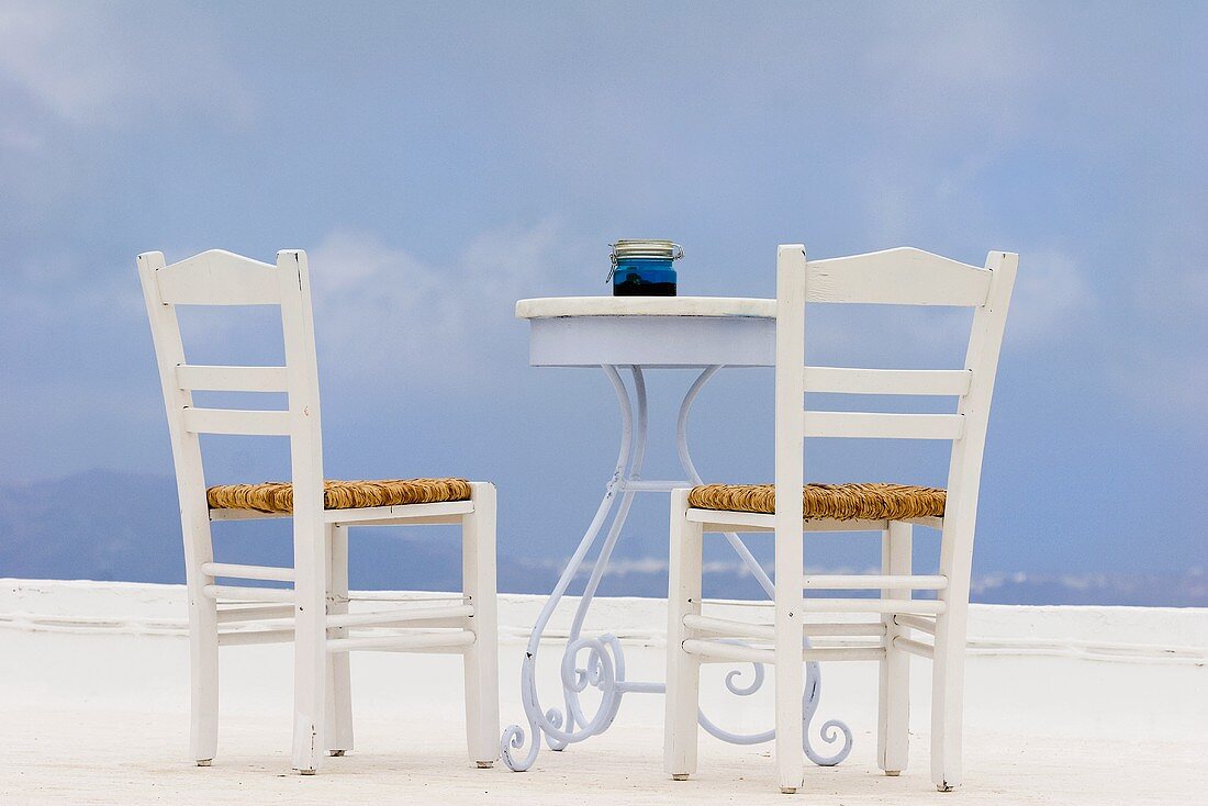 Table and chairs on a terrace with a sea view