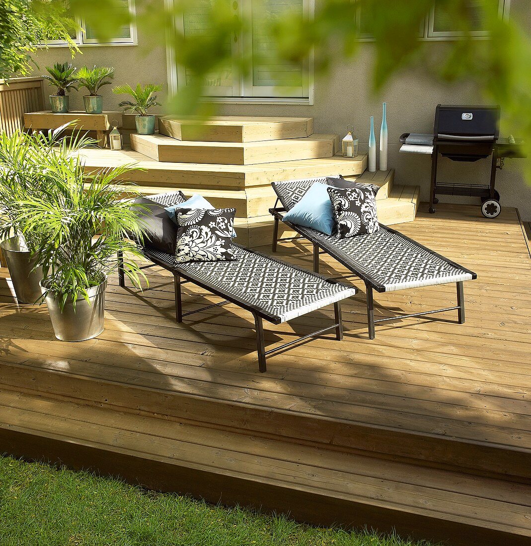 Two loungers and barbecue on decking
