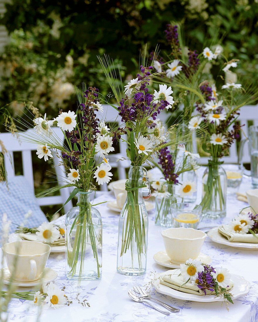 Table decoration of oxeye daisies & meadow clary out of doors