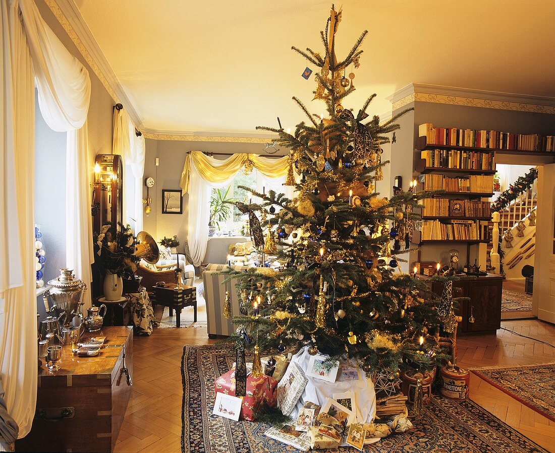 Geschmückter Weihnachtsbaum mit Geschenken in einem Wohnzimmer