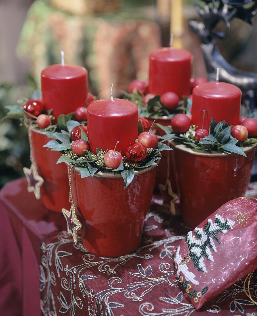 Four red candles with Christmas decorations