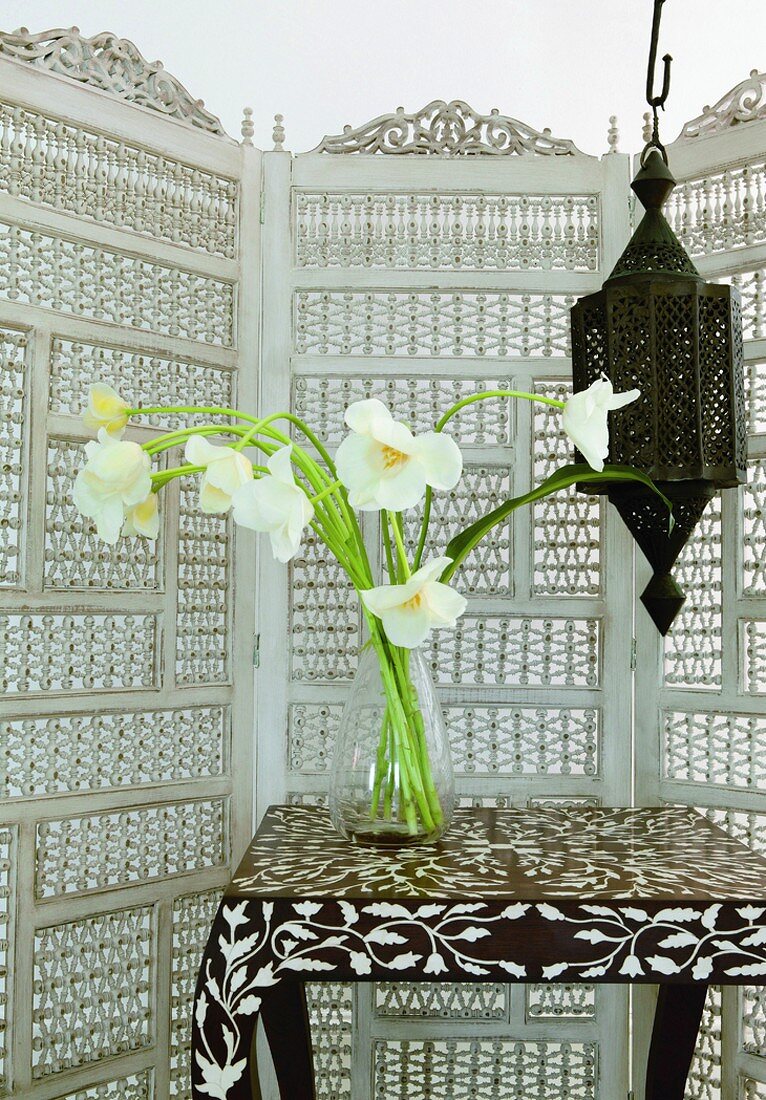 Tisch mit Blumen, Lampe und Raumteiler im marokkanischen Stil