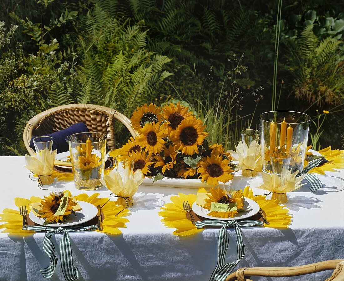 Festlich gedeckter Tisch mit Sonnenblumen im Freien