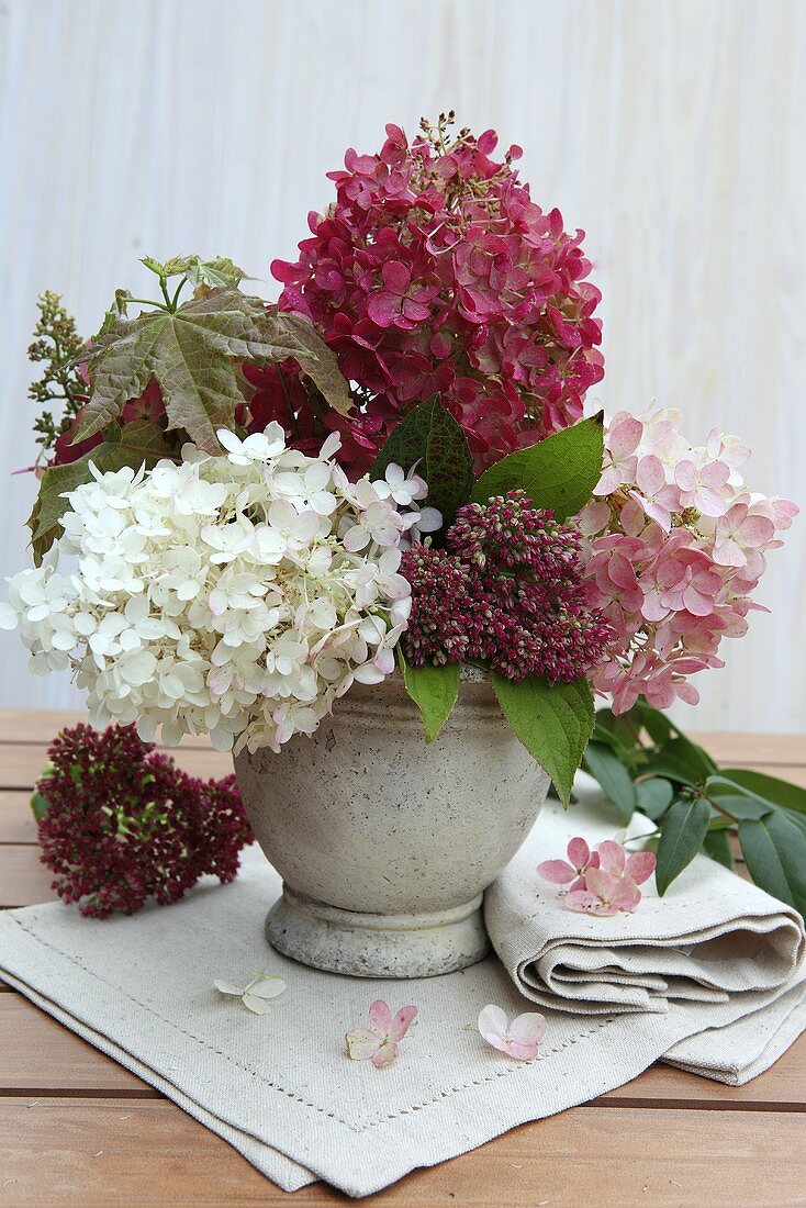 An autumnal bouquet of hortensias in a stone vase