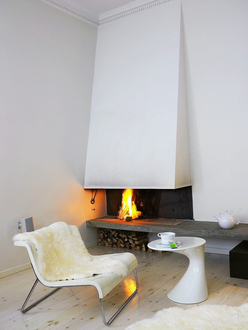 Modernes Wohnzimmer mit offenem Kamin, Stuhl & Designer-Beistelltisch