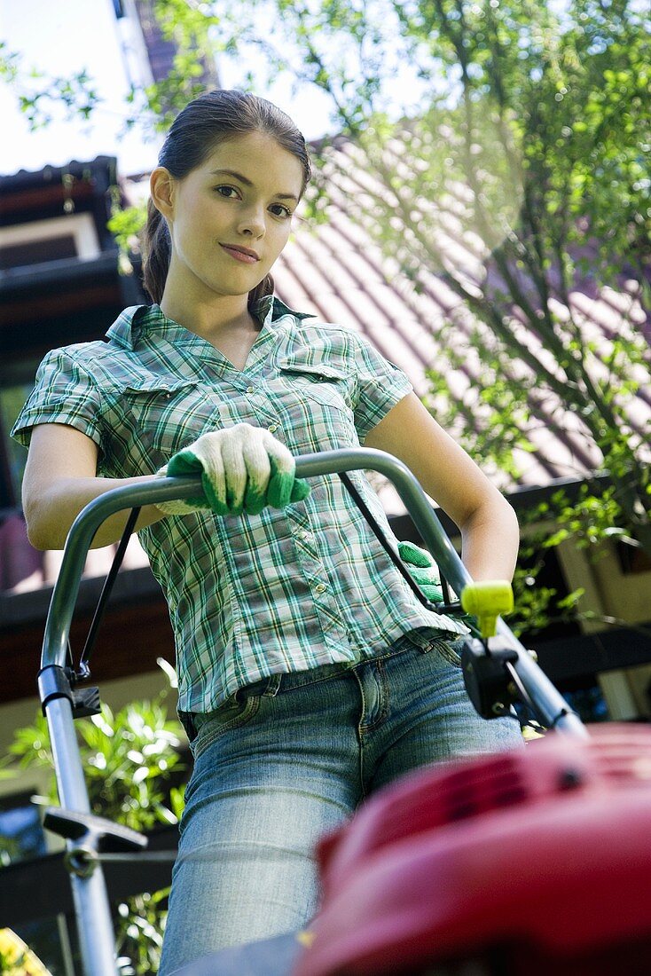 A young woman with a lawn mower