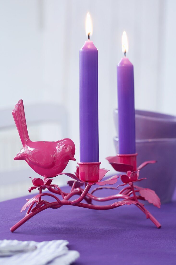 A bird candle holder with purple candles