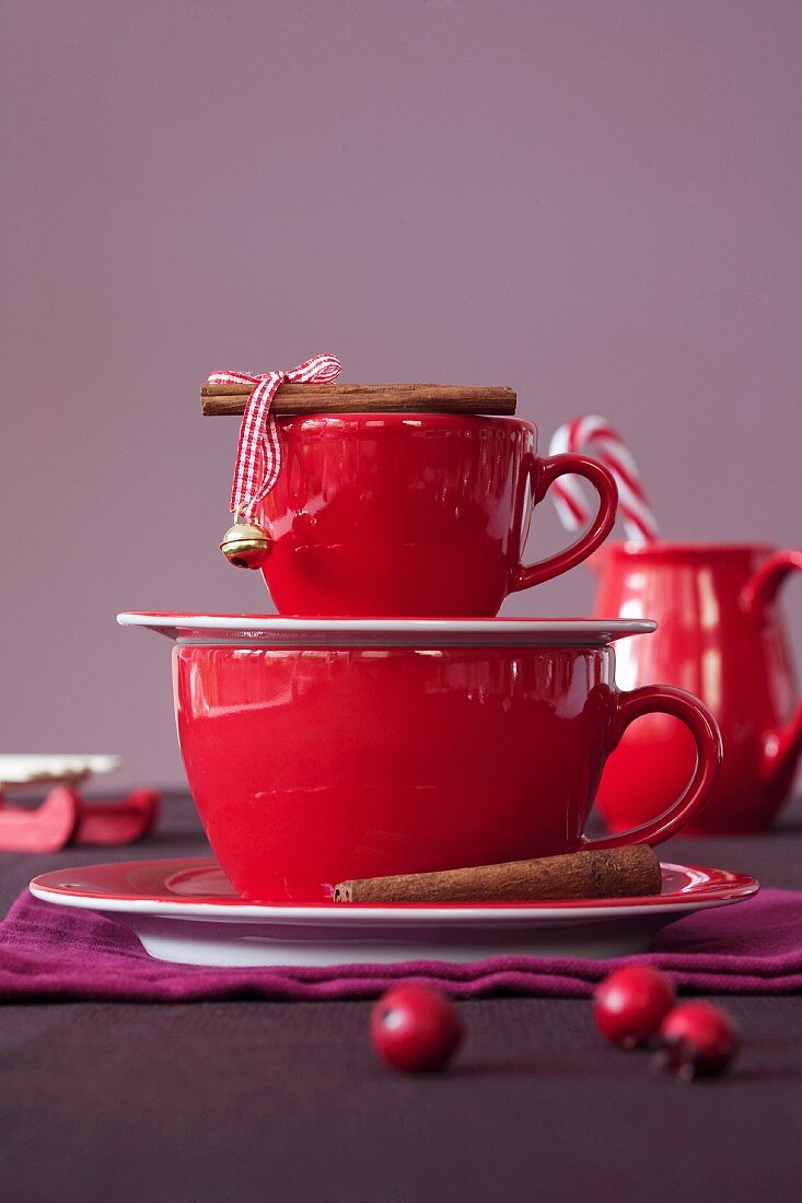 Rote Espressotasse und Kaffeetasse mit Zimtstangen