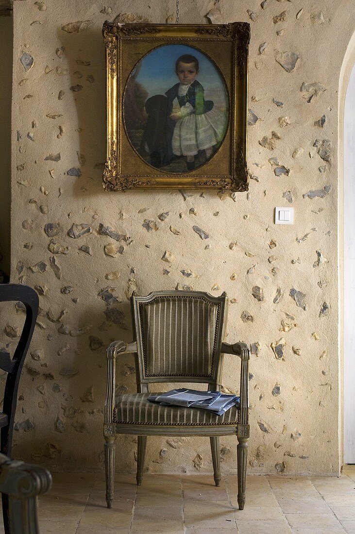Chair beneath painting on the wall