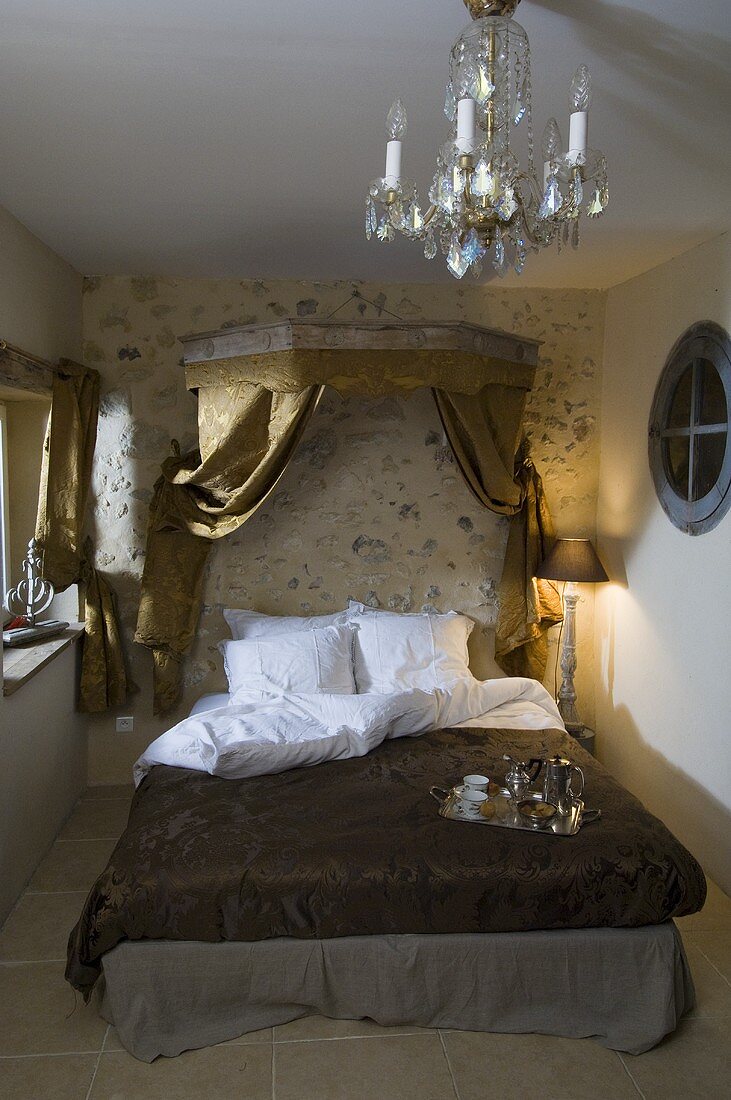 Schlafzimmer mit Doppelbett, Himmel mit goldfarbenen Vorhängen & Kronleuchter