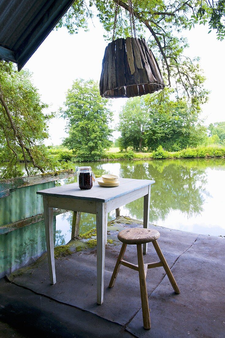 Table and chair on the verandah of a boathouse