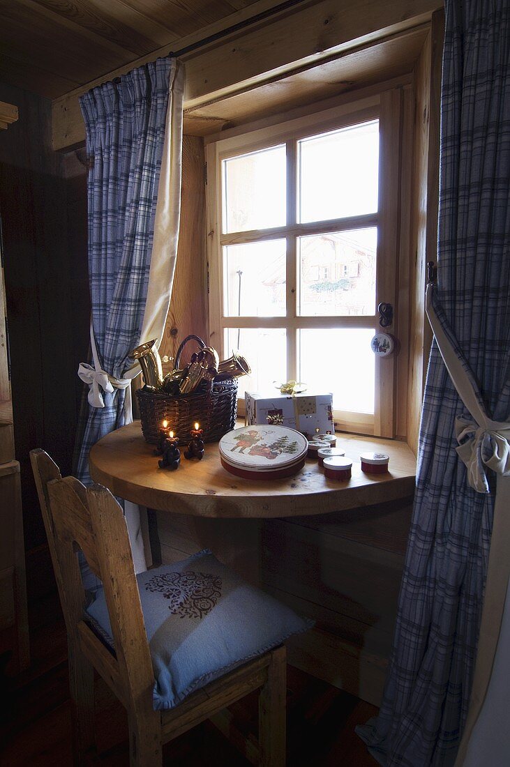 Weihnachtdeko auf Wandtisch am Fenster eines Landhauses