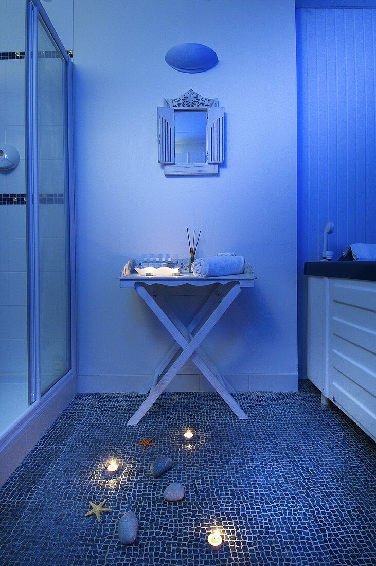 Bläulich beleuchtetes Badezimmer mit Mosaikfliesenboden & maritimer Deko