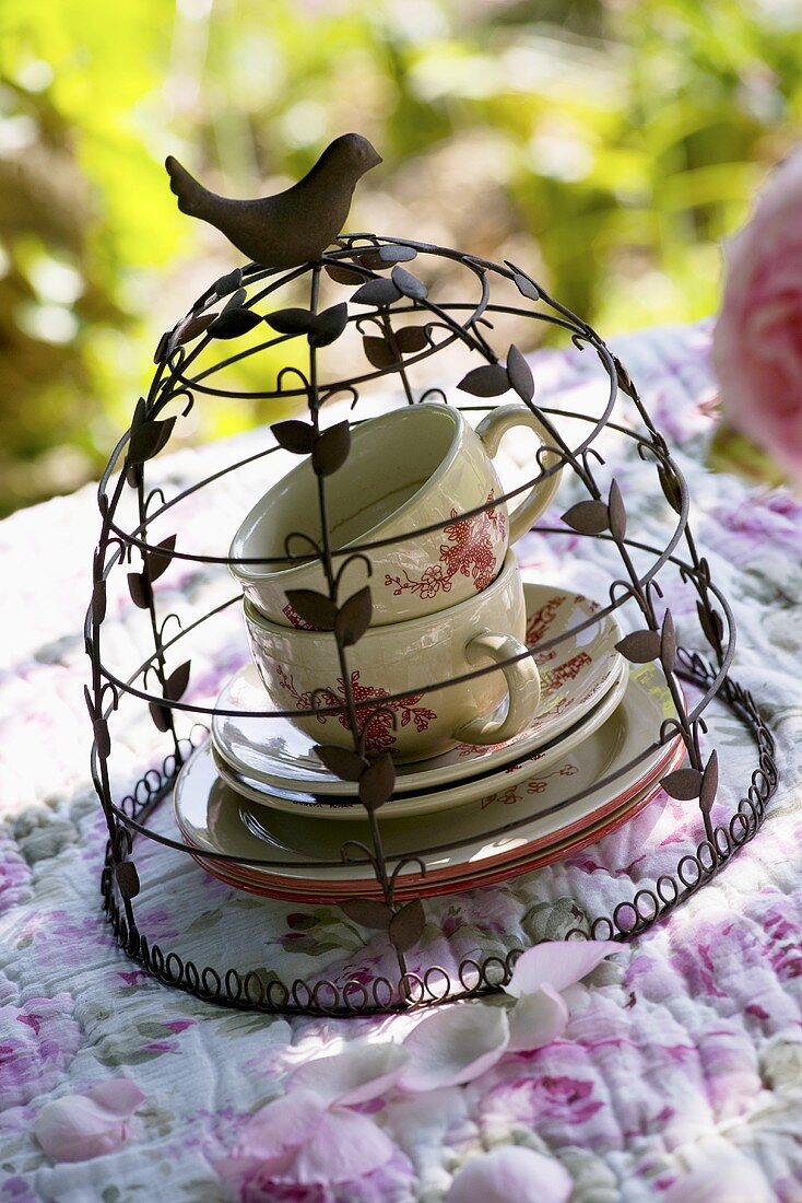 Teacups under decorative cover on romantic table