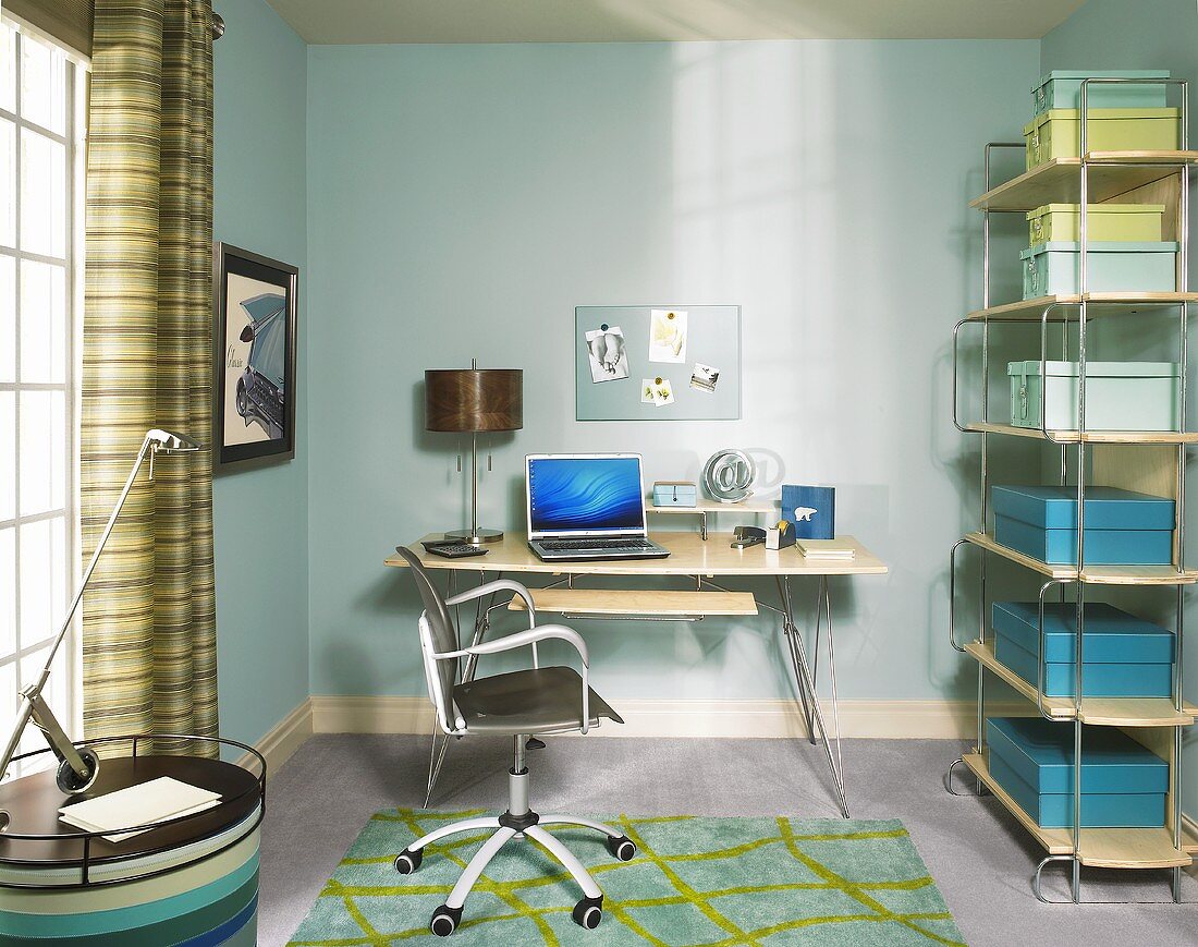 Büroraum in blauen Farbtönen mit Schreibtisch, Drehstuhl & Aufbewahrungsboxen in Metallregal