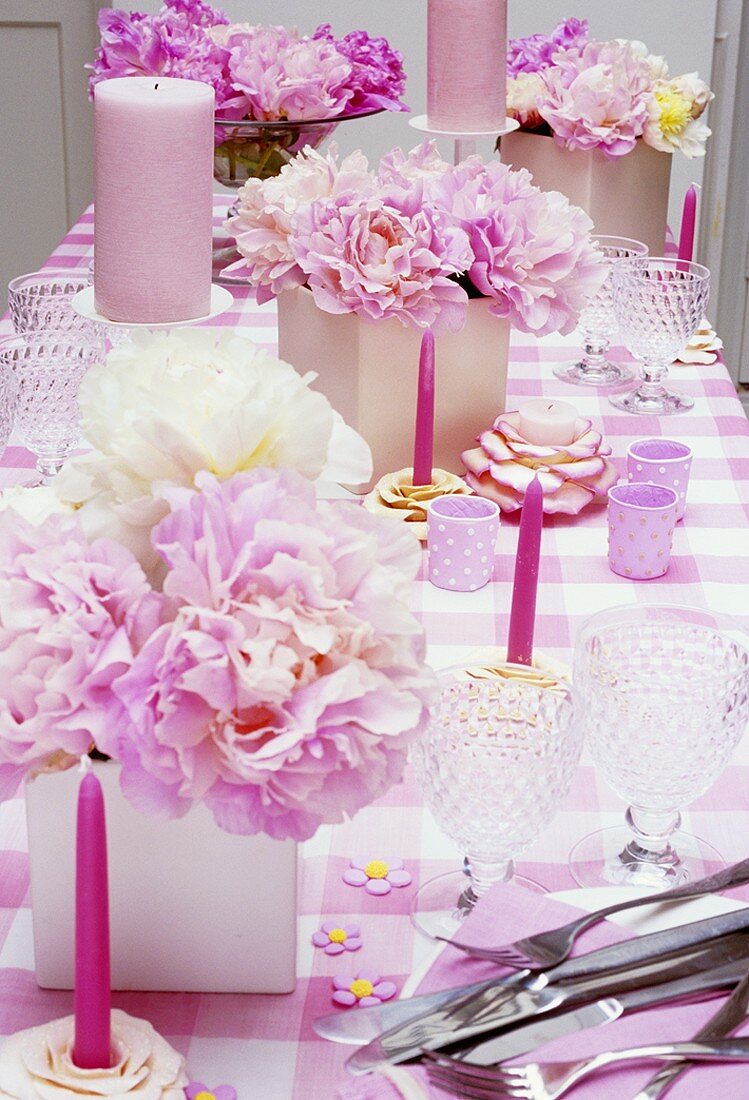 Gedeckter Tisch mit rosa Accessoires & Pfingstrosen