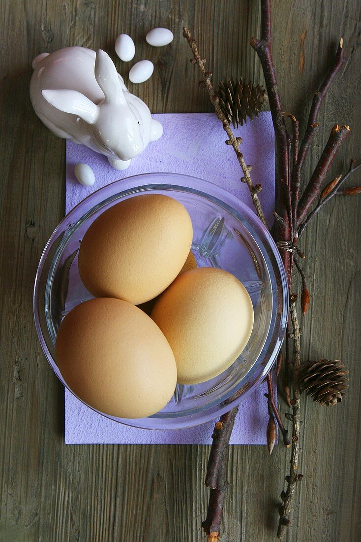Three eggs in a glass dish with porcelain rabbit