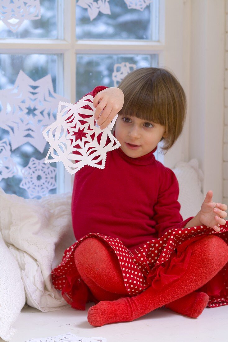 Girl playing with snowflake decoration