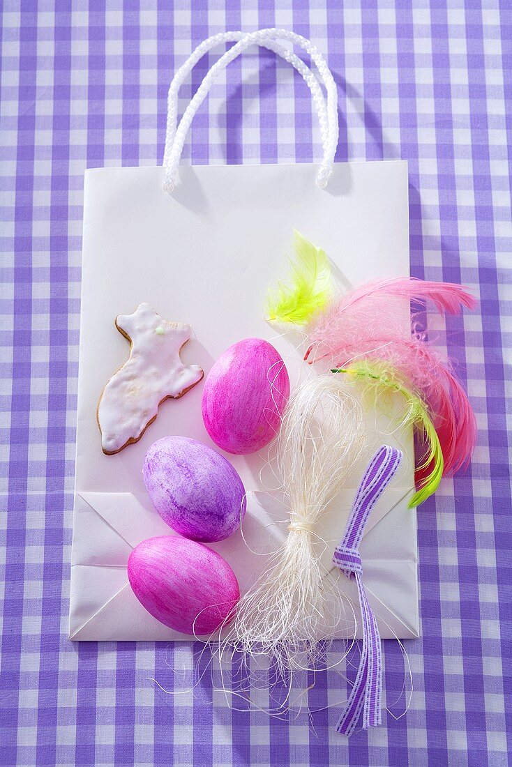 Easter eggs, Easter Bunny biscuit, feathers on paper carrier bag
