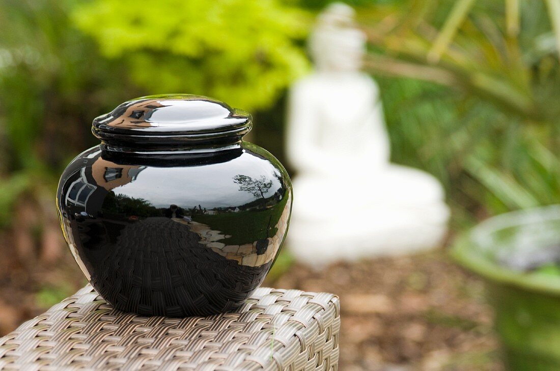 A black jar with lid in an oriental garden, Burma