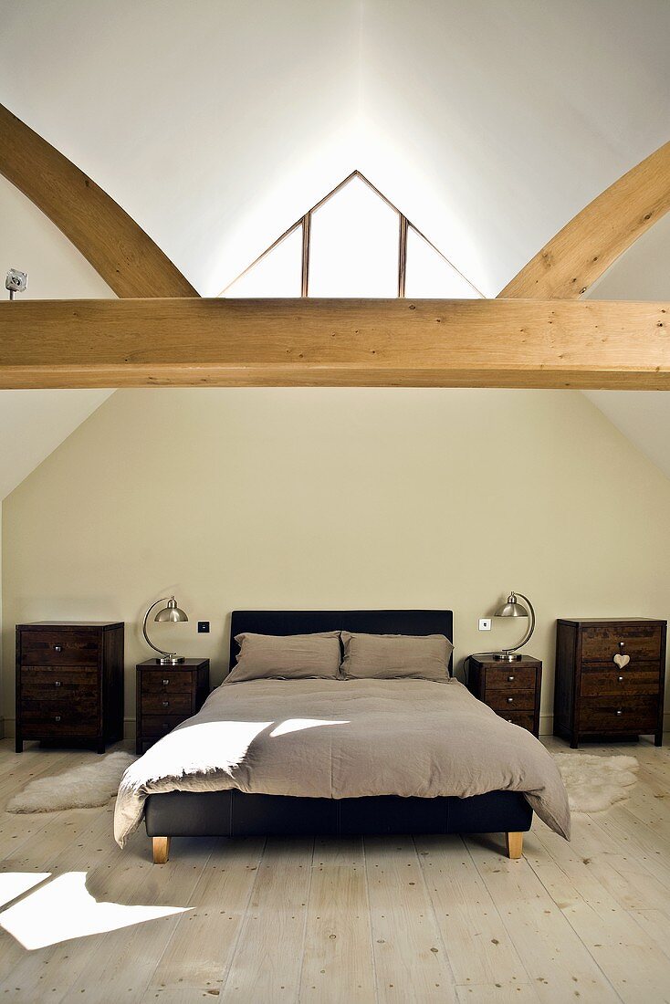 Schlafzimmer im Dachgeschoss mit Holzbalken, Holzboden & Doppelbett