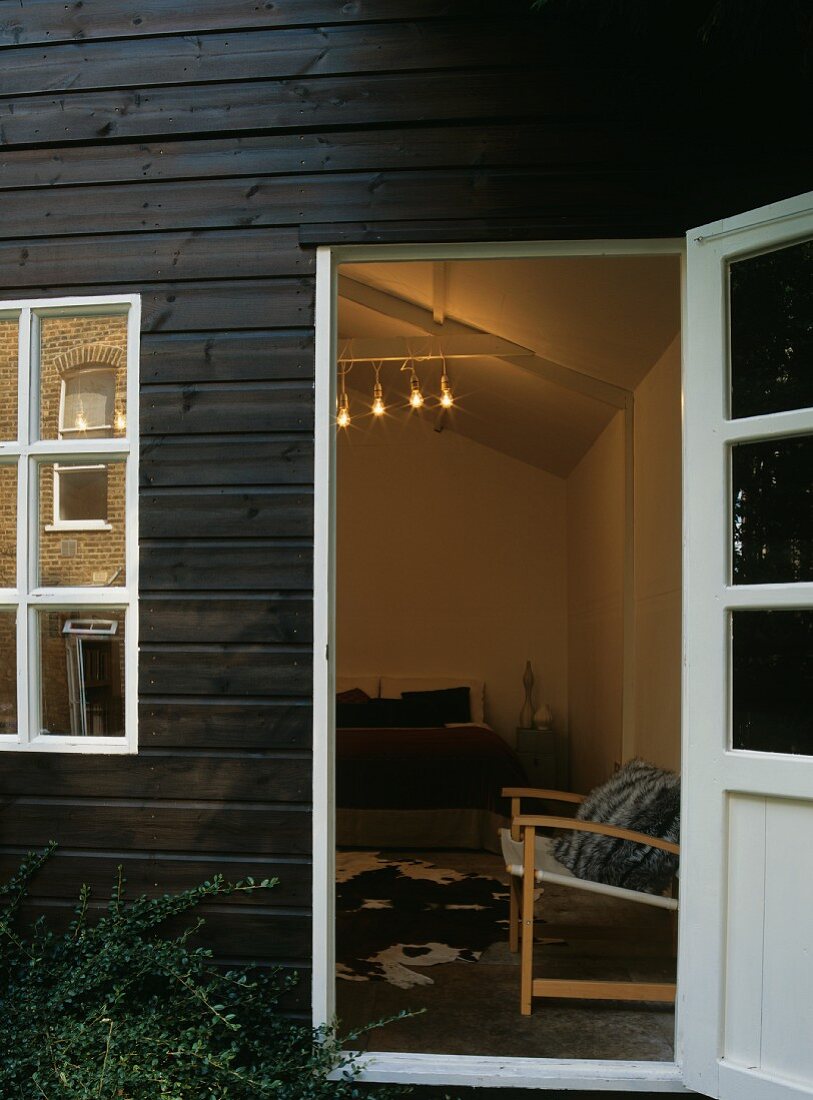 Wooden house with open door leading to bedroom