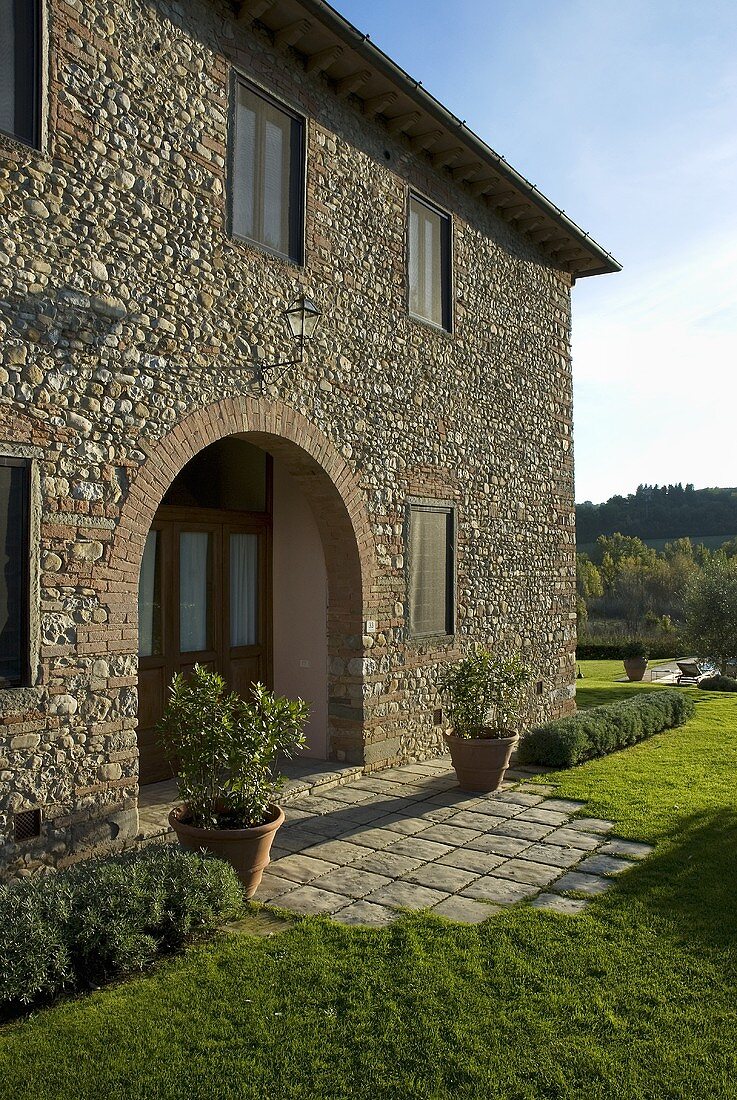 Mediterranean country home with stone facade a terraced area