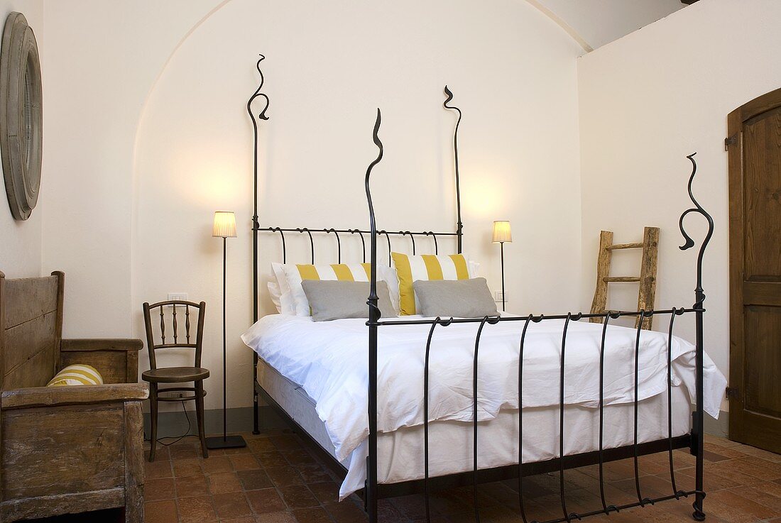 Schmiedeeisernes Bett mit weisser Bettwäsche im Mediterraner Landhaus