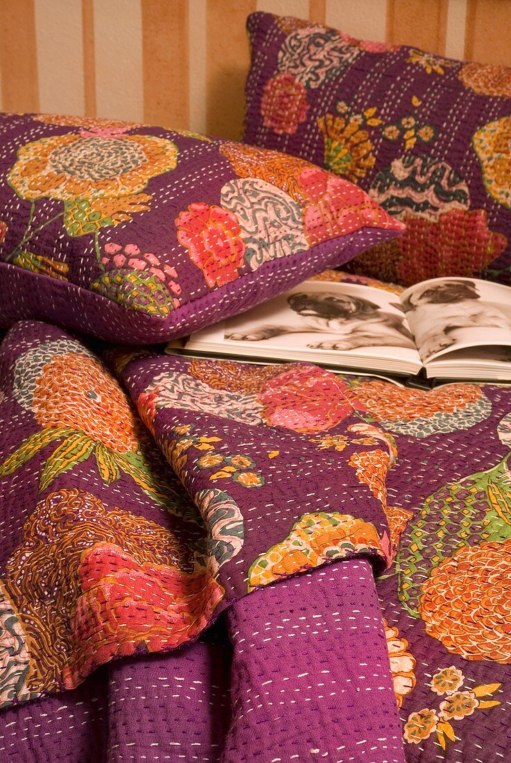Bedspread and pillows covered in the same colorful fabric