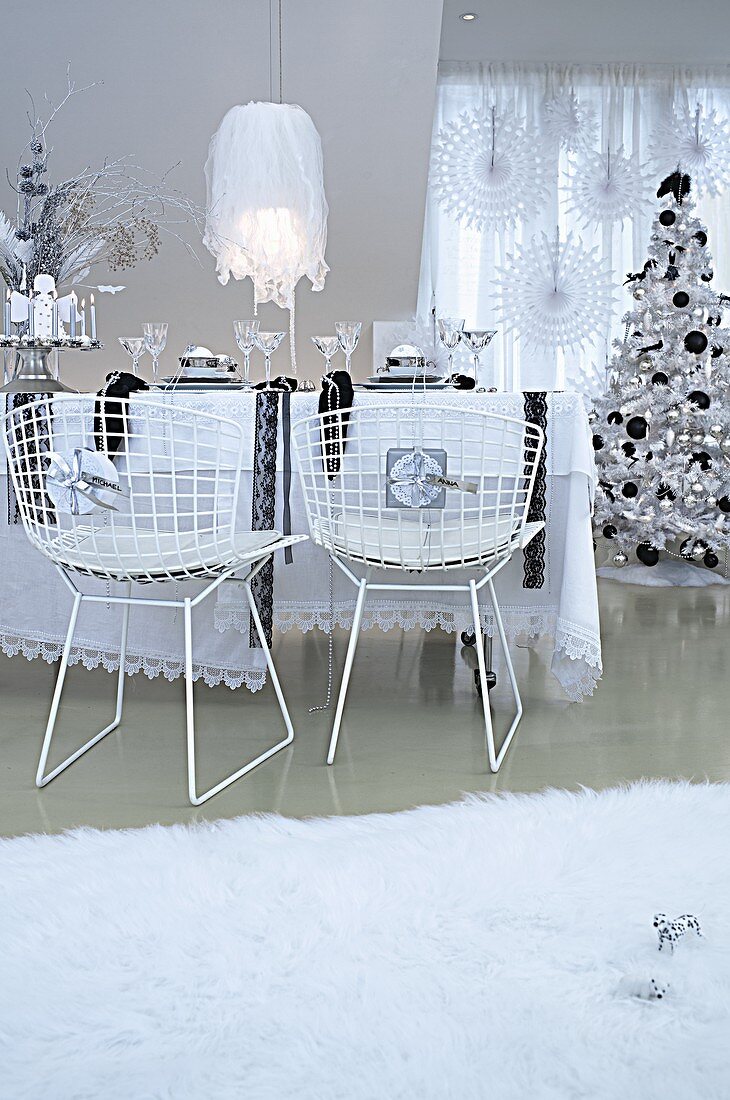 Esszimmer weihnachtlich dekoriert in Schwarz- & Weisstönen mit Esstisch, Drahtstühlen & Weihnachtsbaum