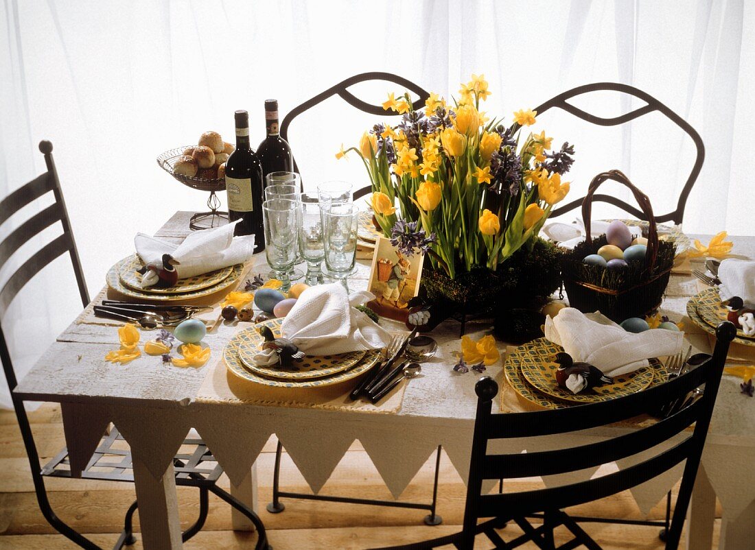 A festively laid Easter table in a country house style decorated with spring flowers