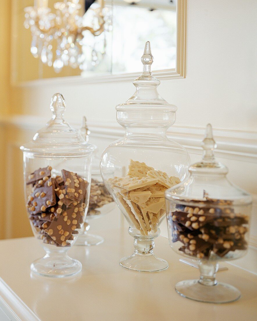 Sweets in glass containers on chest of drawers