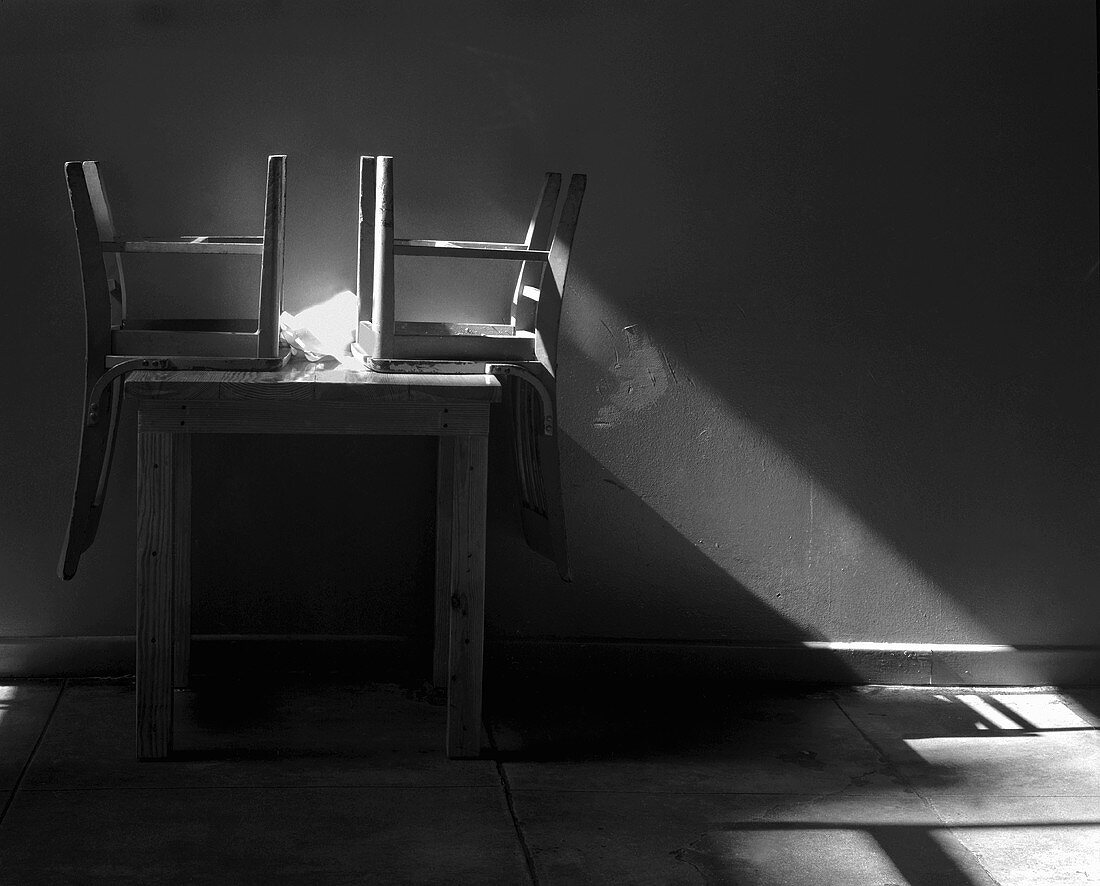 Sunlight Shining on Two Chairs Overturned on a Table