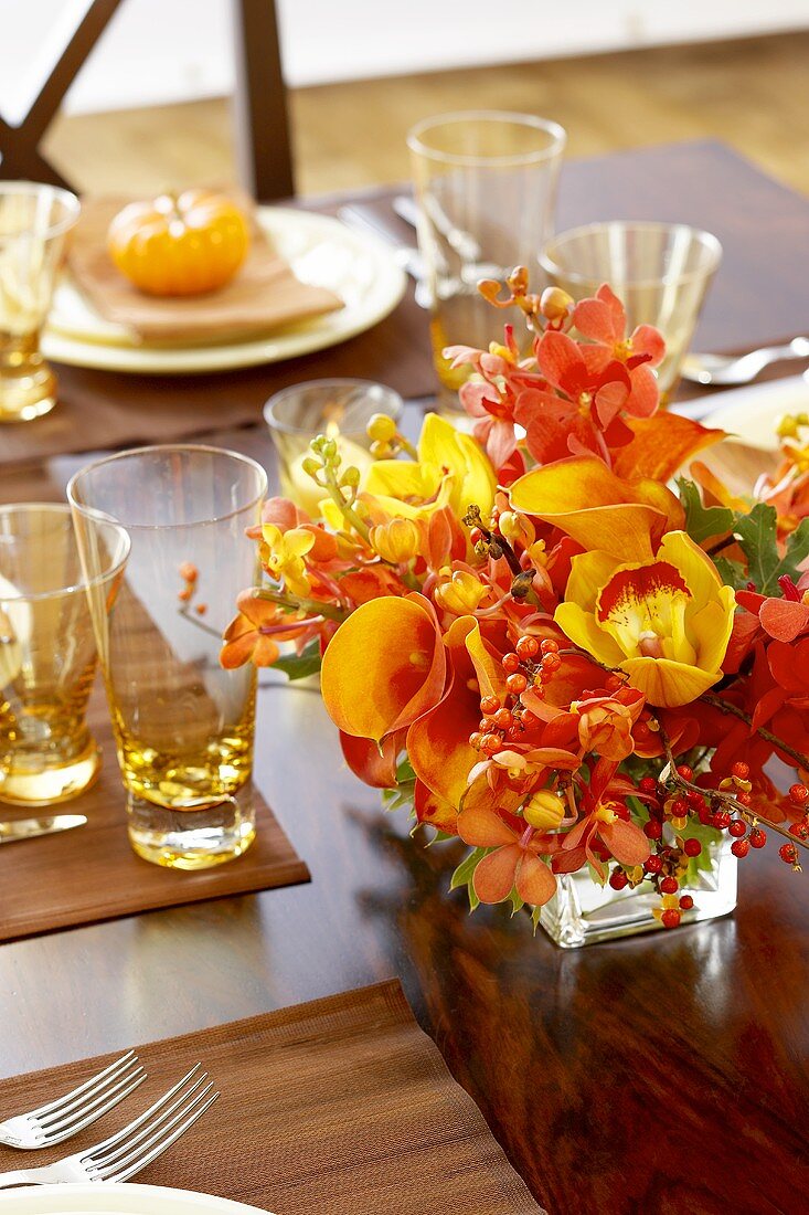 Blumendeko am herbstlich gedeckten Tisch