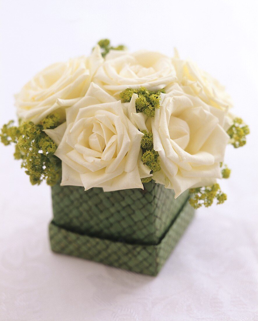 weiße Rosen in einer grünen Schachtel