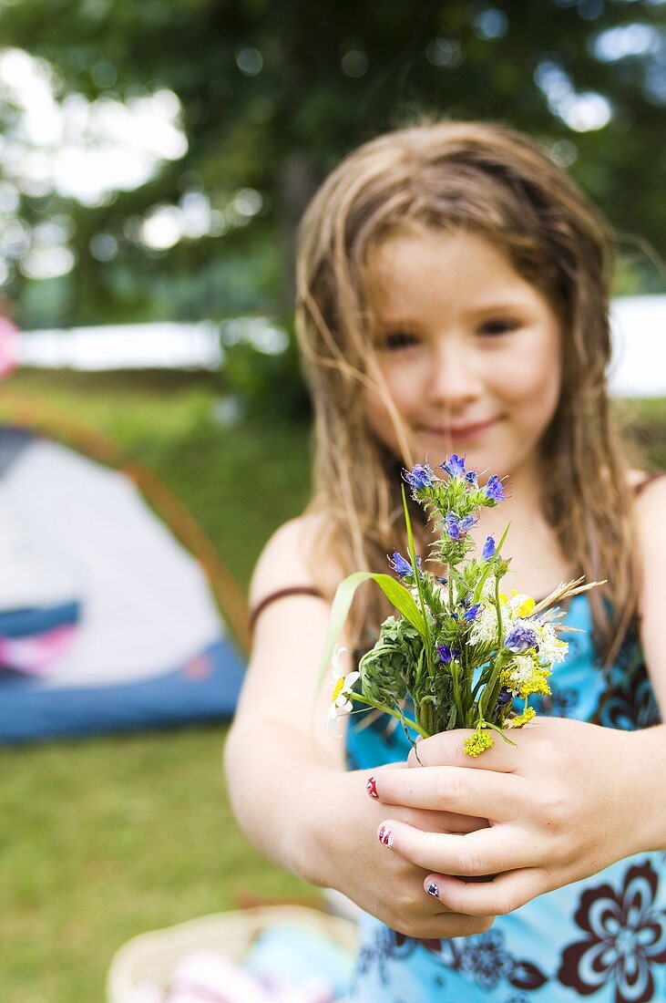 Young Girl Holding a Bouquet of Wildflowers; Campsite