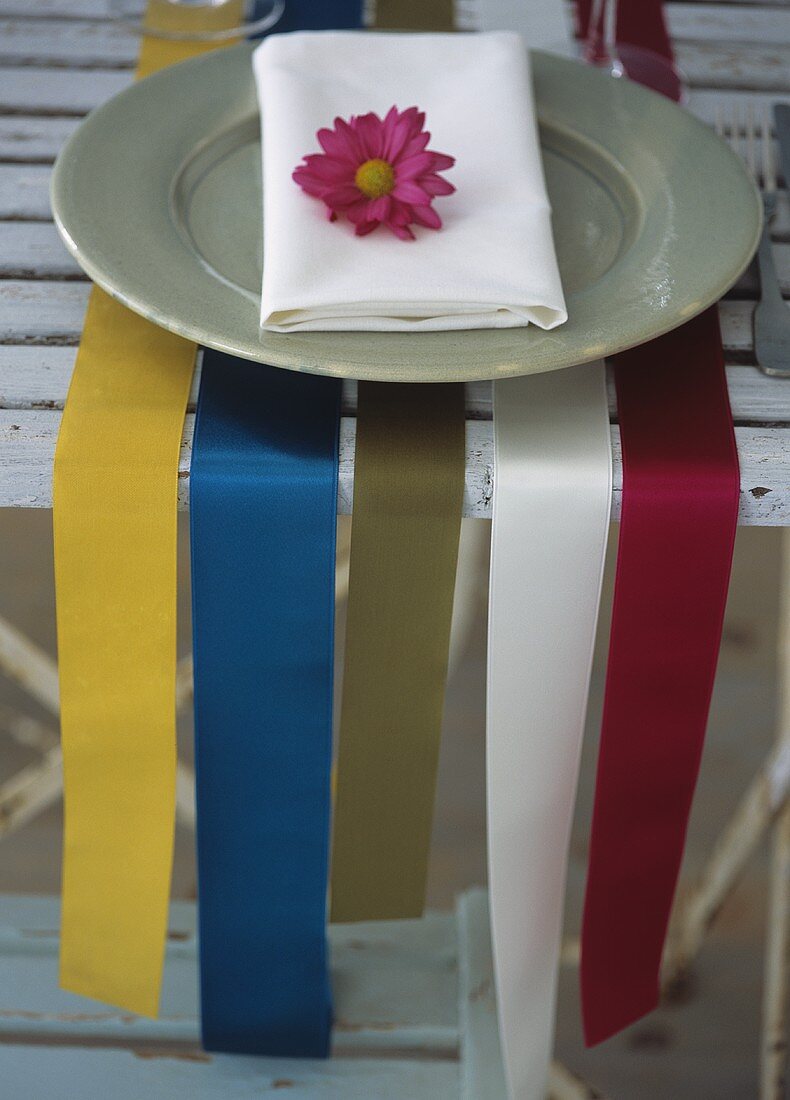 Wide ribbons as a place setting with a plate and a serviette