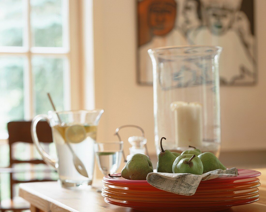 A stack of plates with pears on a dining table