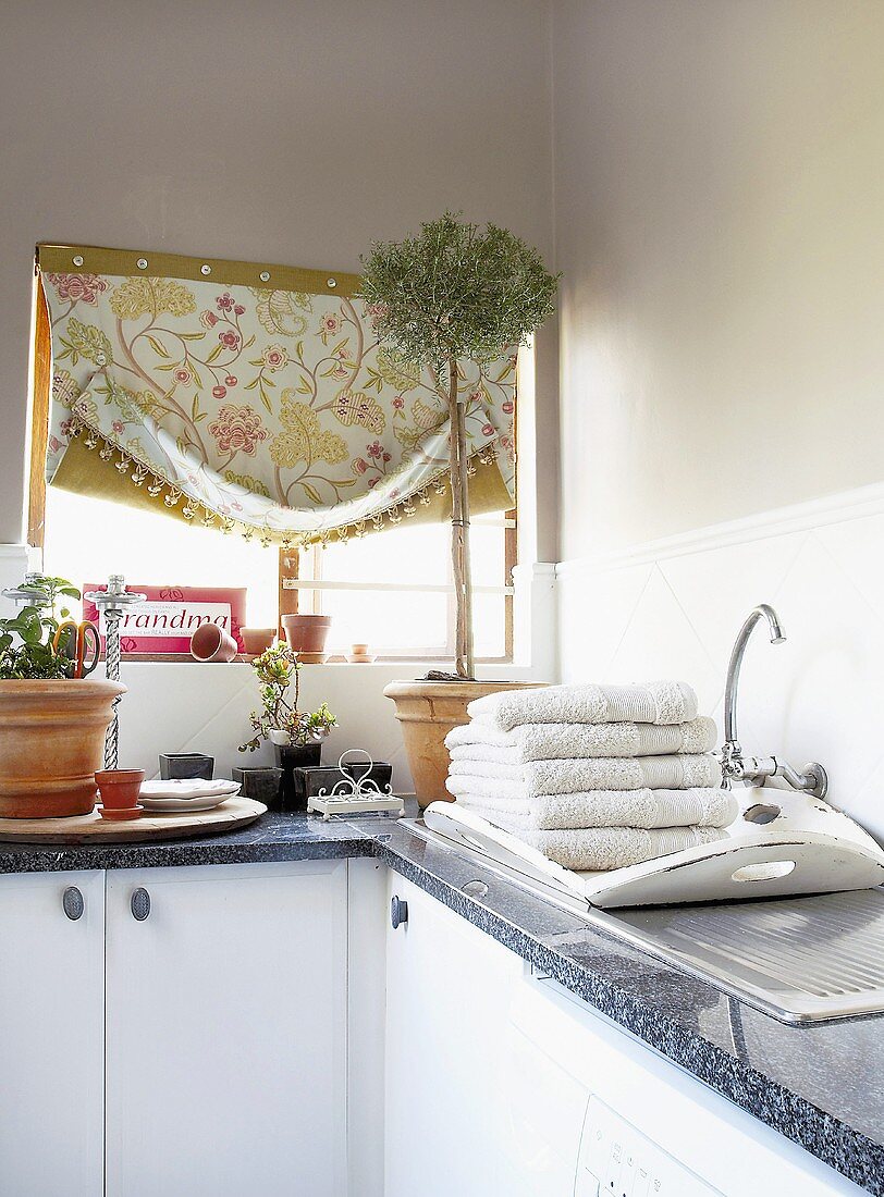 A kitchen window above a countertop drapped with fabric