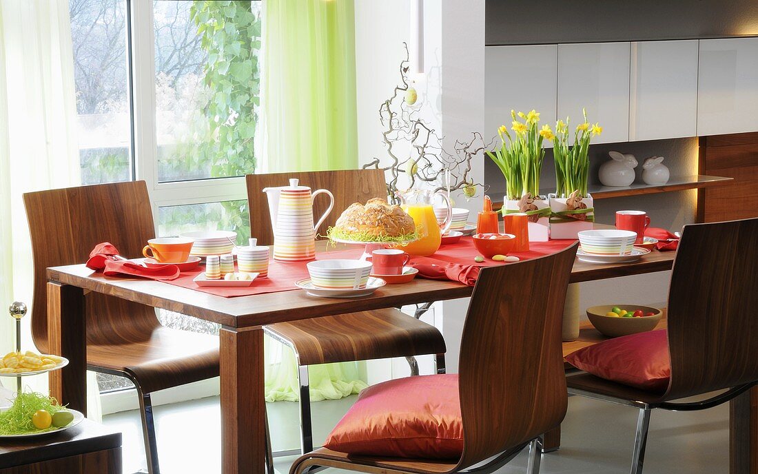 Gedeckter Tisch fürs Osterfrühstück mit Esstisch und Stühlen aus Nussbaumholz