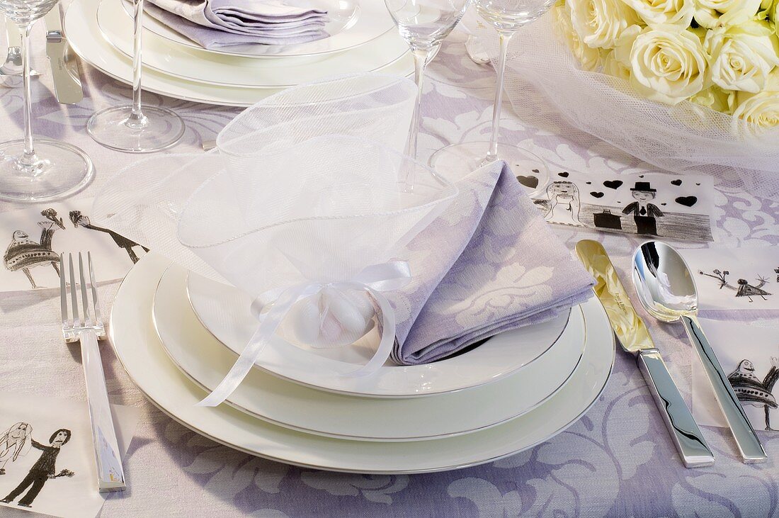 Tischgedeck festlich dekoriert mit Stoffserviette und verpackter Süssigkeit