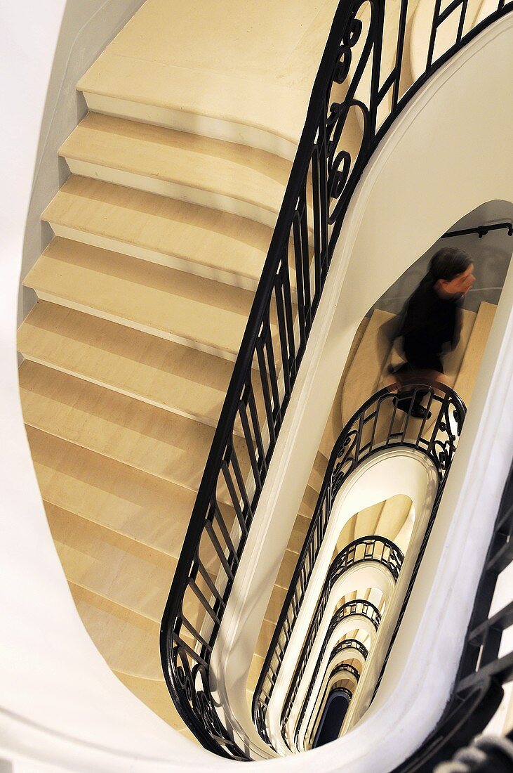 Blick in ein Treppenauge eines Herrschaftshauses mit schwarzem Geländer