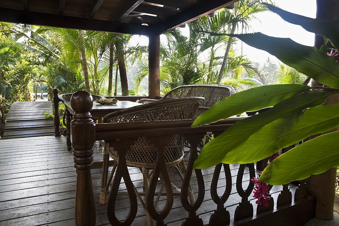 A seating area on a wooden terrace in tropical surroundings