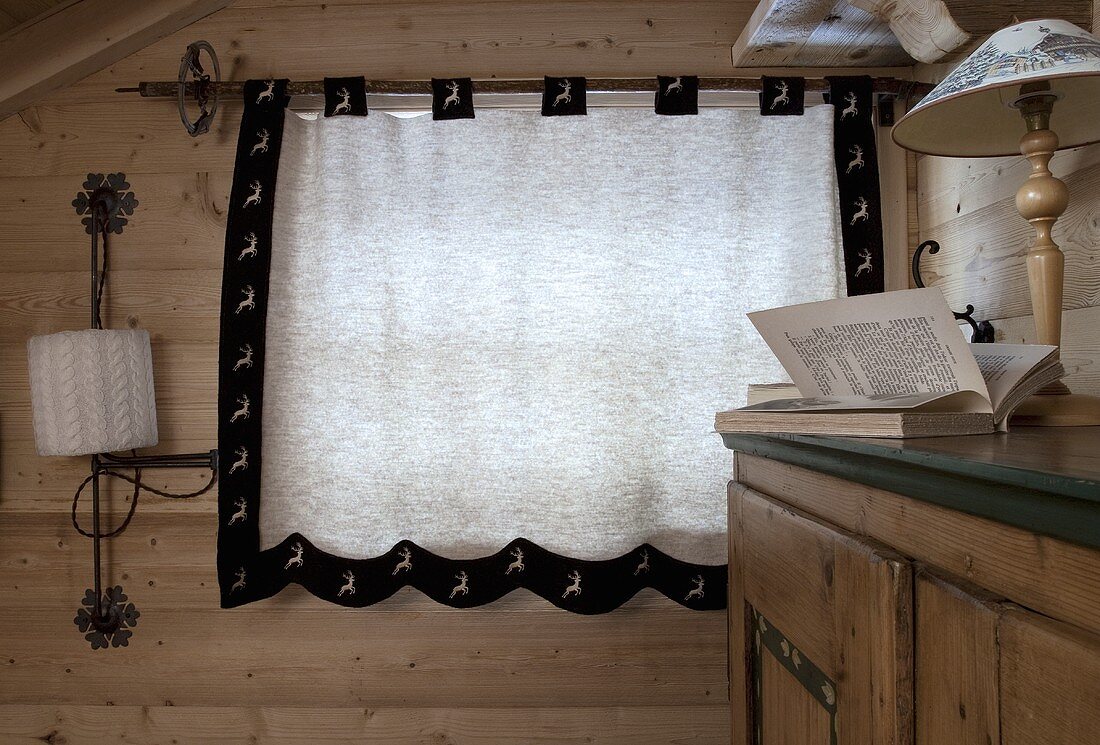 A curtained-window in a wood-panelled room
