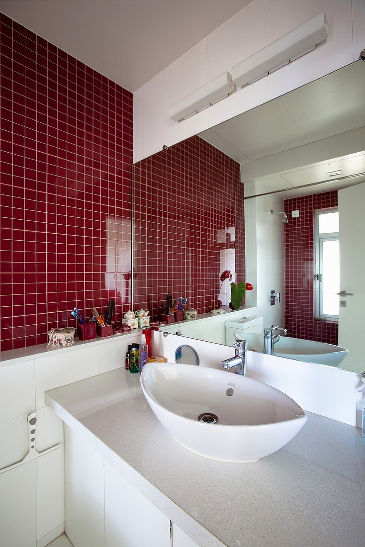 Badezimmer mit rotgefliester Wand, Waschtisch & Spiegelwand