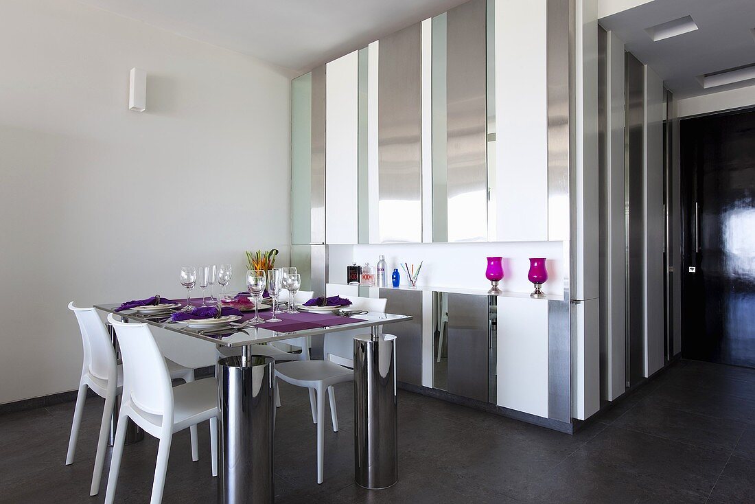 Wohnraum mit gedecktem Esstisch & Einbauschrank in Stahl-Glasausführung als Raumtrenner