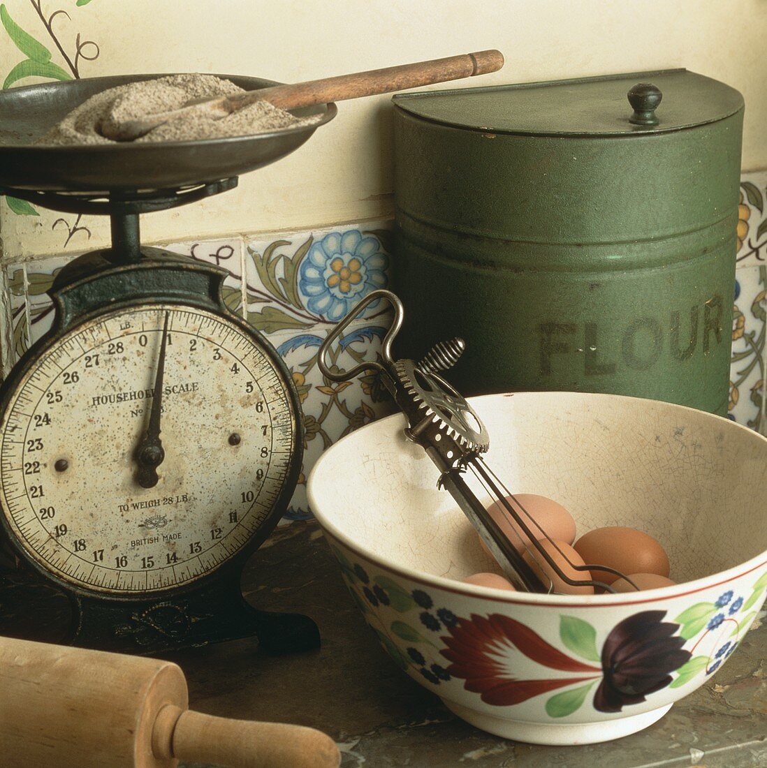 Alte Küchenwaage, Mehldose, Schale mit Eiern & altem Handrührgerät
